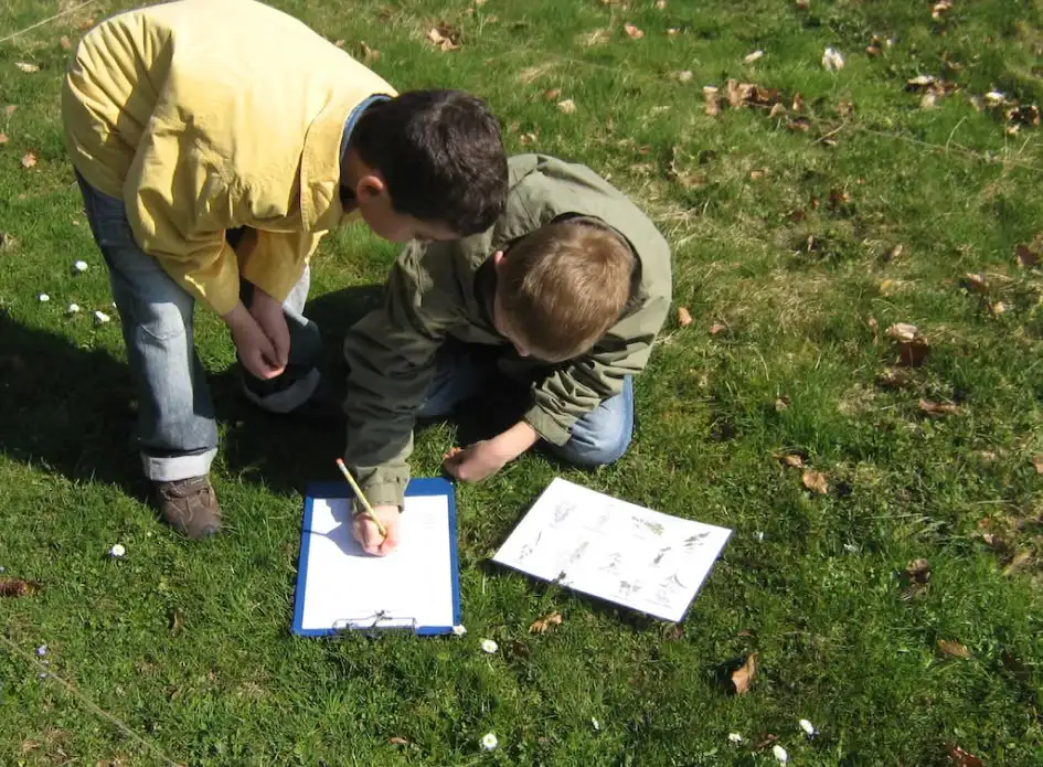 deux enfants sur la pelouse entrain d'ecrire 