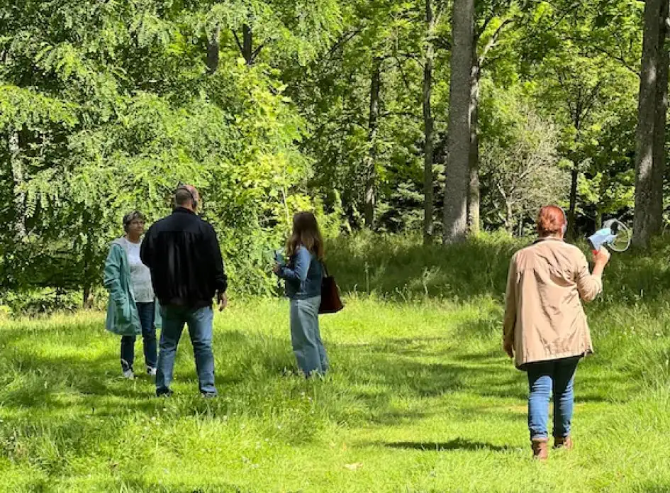 Un groupe de personnes est entrain d'écouter des sons dans une forêt